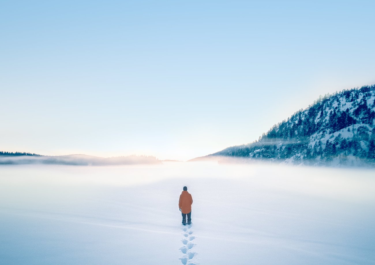 Vinterlandskap. Mann som går på frossen innsjø
