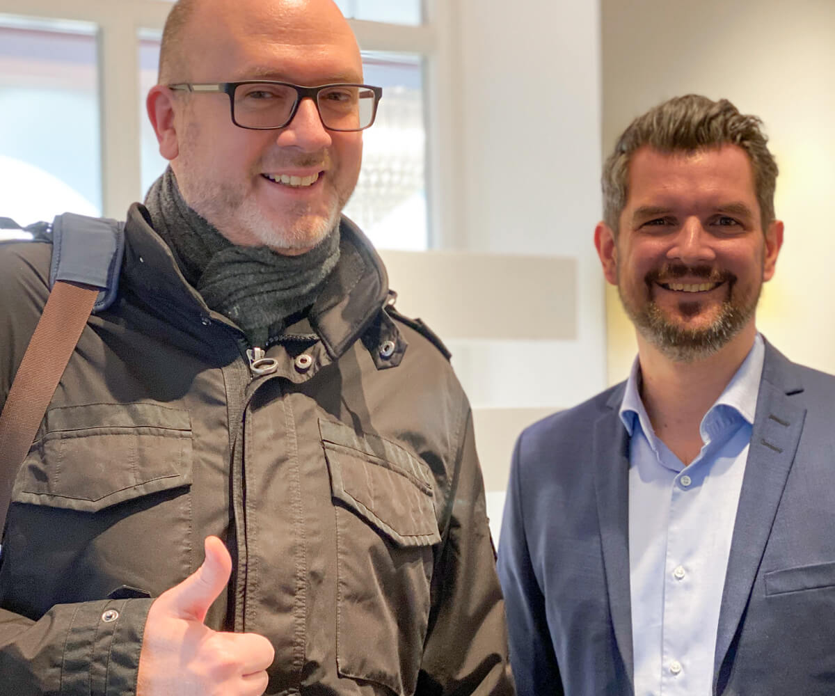 Smilende mann gir "thumbs up"