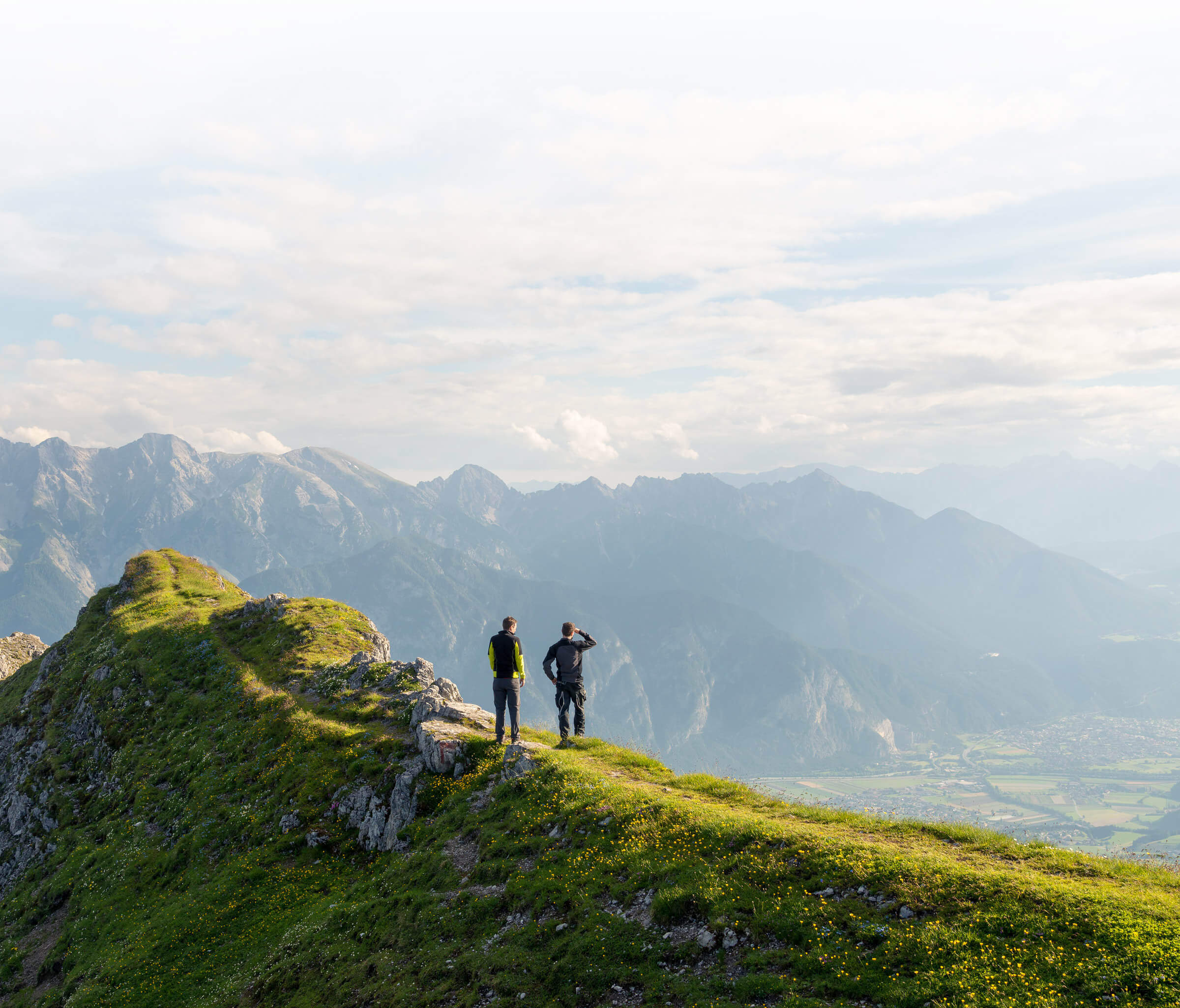 To menn på toppen av et fjell nyter utsikten