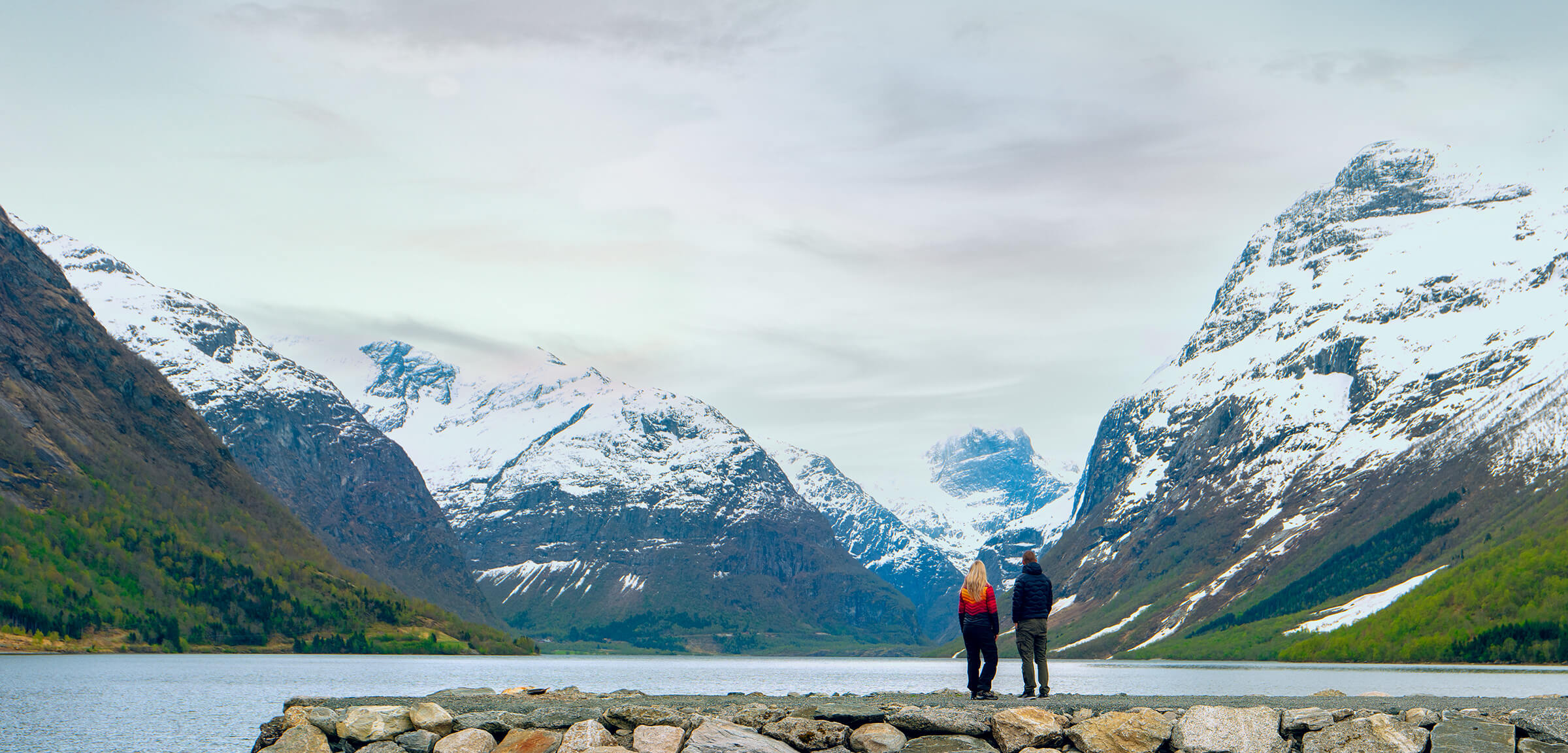 Et par på en steinbrygge med utsikt over fjell