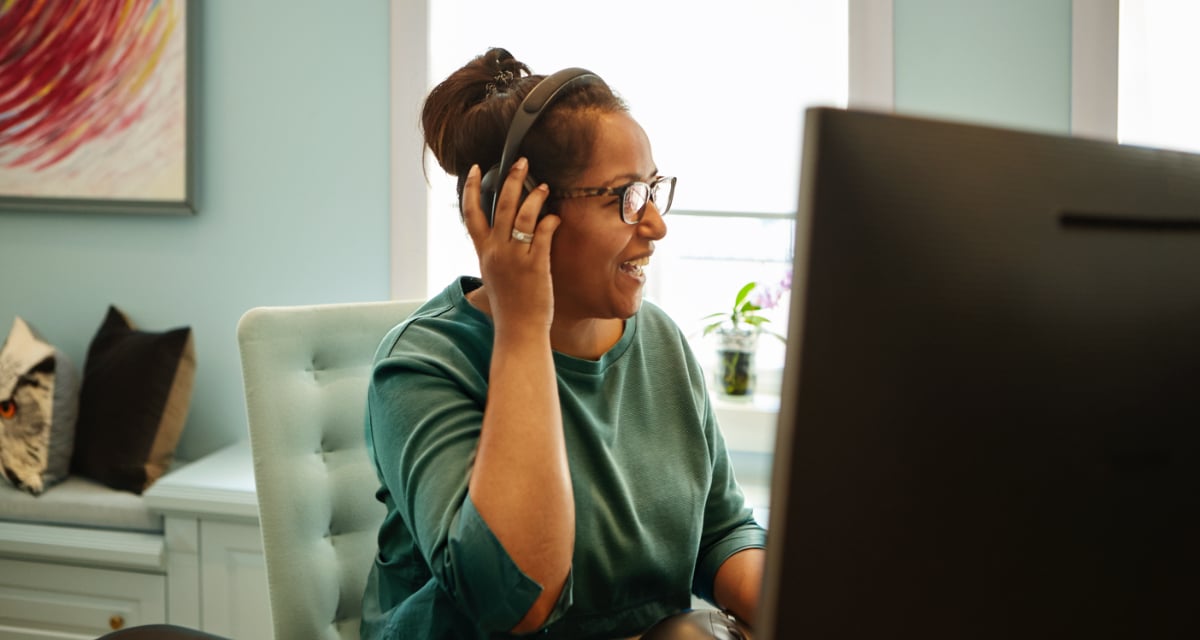 Foto av kvinne med headset foran en pc skjerm